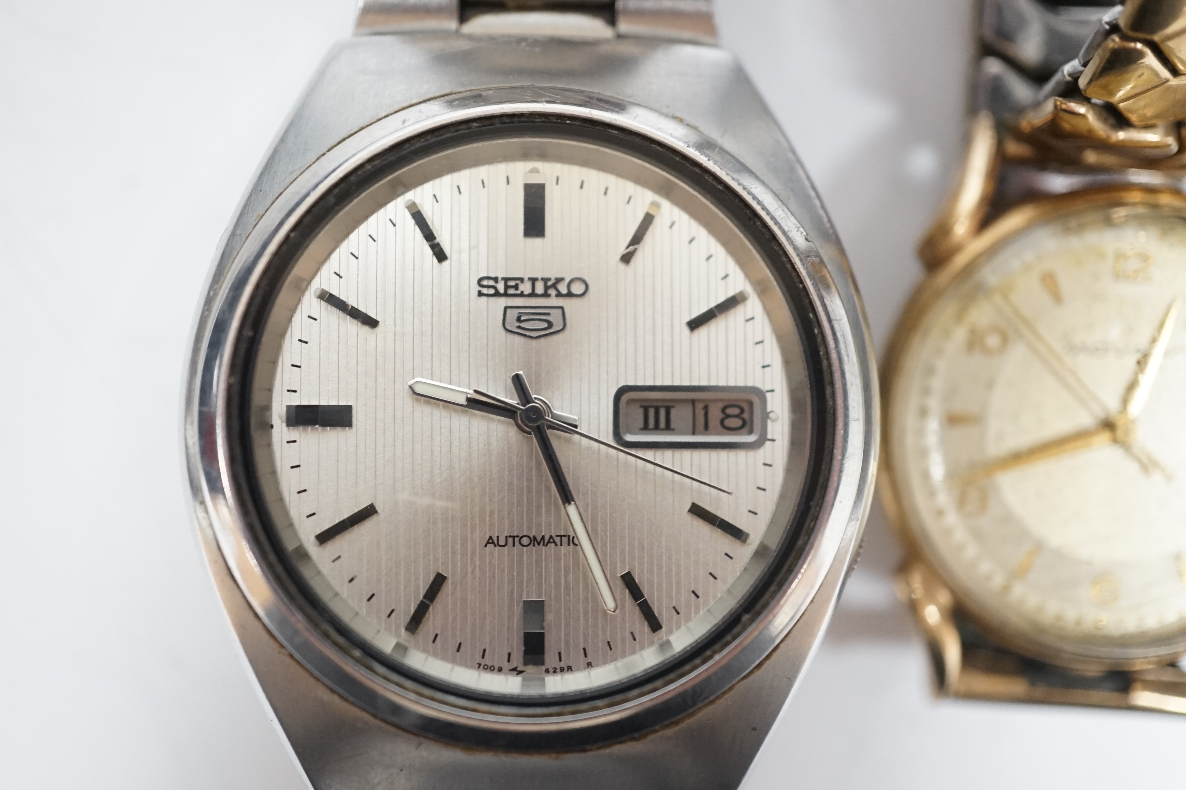 A gentleman's 9ct gold Movado manual wind wrist watch, on associated steel and gold plated flexible strap and a gentleman's stainless steel Seiko 5 automatic wrist watch.